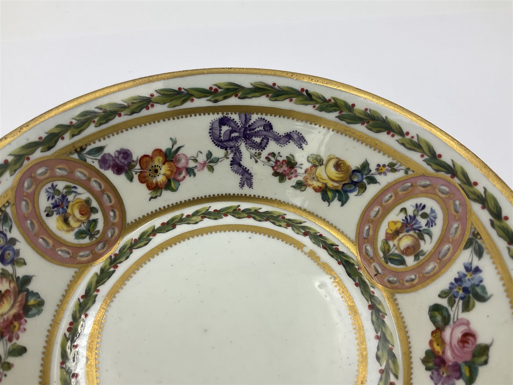 Sèvres soft paste porcelain coffee can and saucer with date code for 1780, painted with pink oval panels bordering bouquets of flowers, united by swags of flowers tied with purple ribbons, within laurel leaf borders, interlaced LL monogram enclosing date letters CC above painters marks for Nicquet, coffee can H7.5cm, saucer D15cm