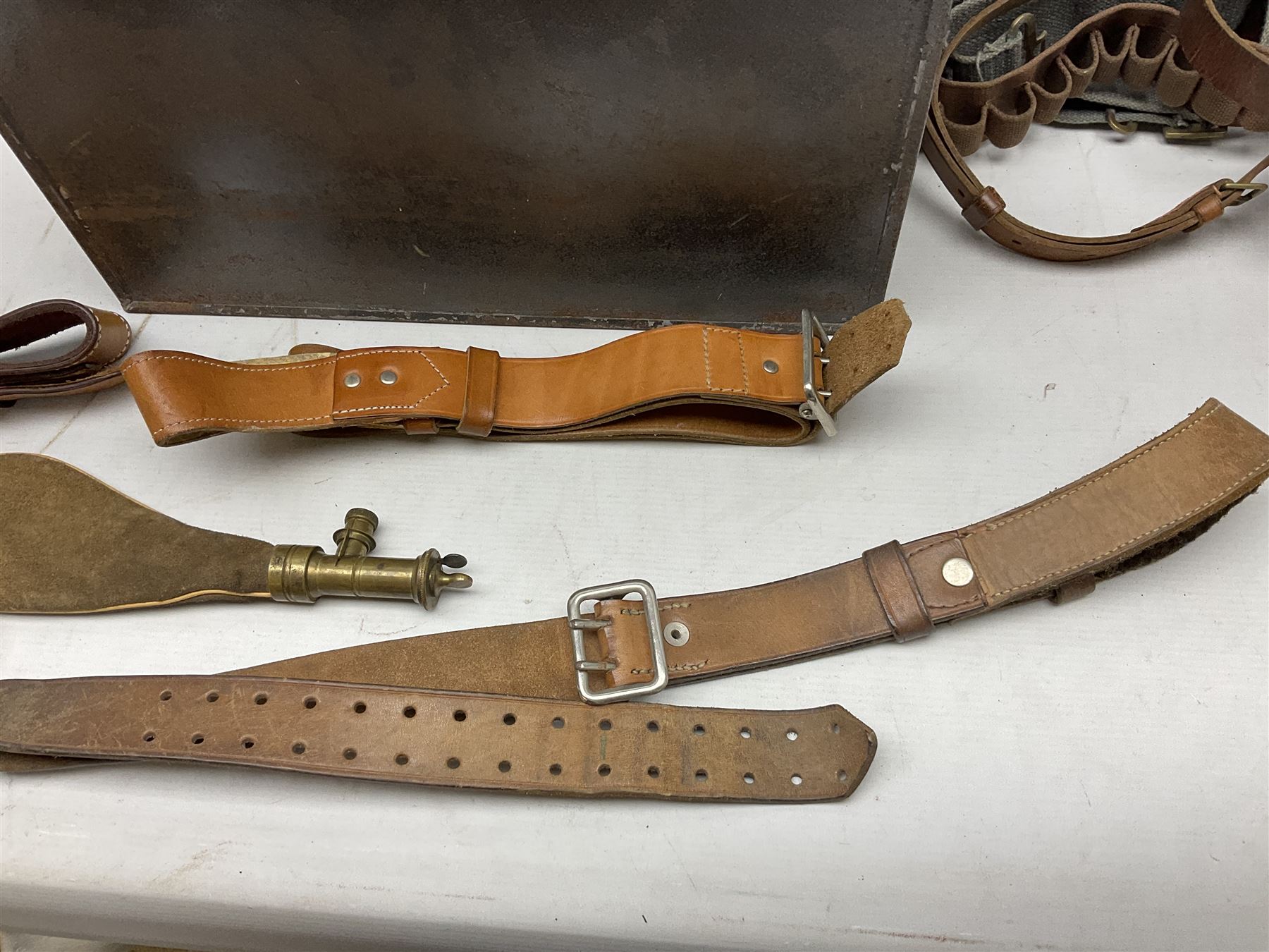 Assorted militaria including ten leather or canvas cartridge and other belts, maroon beret with 17th Lancers cap badge, modern bullet mould, leather and brass shot flask, two knives, shell cases, boomerang etc; in tin deed box