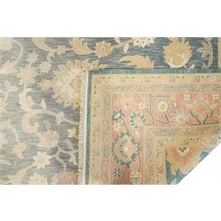 Indo-Persian indigo ground carpet, the field decorated with large palmette motifs connected by scrolling foliate, enclosed nu wide guard bands decorated with repeating interlaced stylised plant motifs