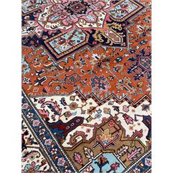 Large Persian carpet, the geometric and stylised floral medallion on rust ground field decorated with stylised plant motifs, guarded ivory border with repeating pattern