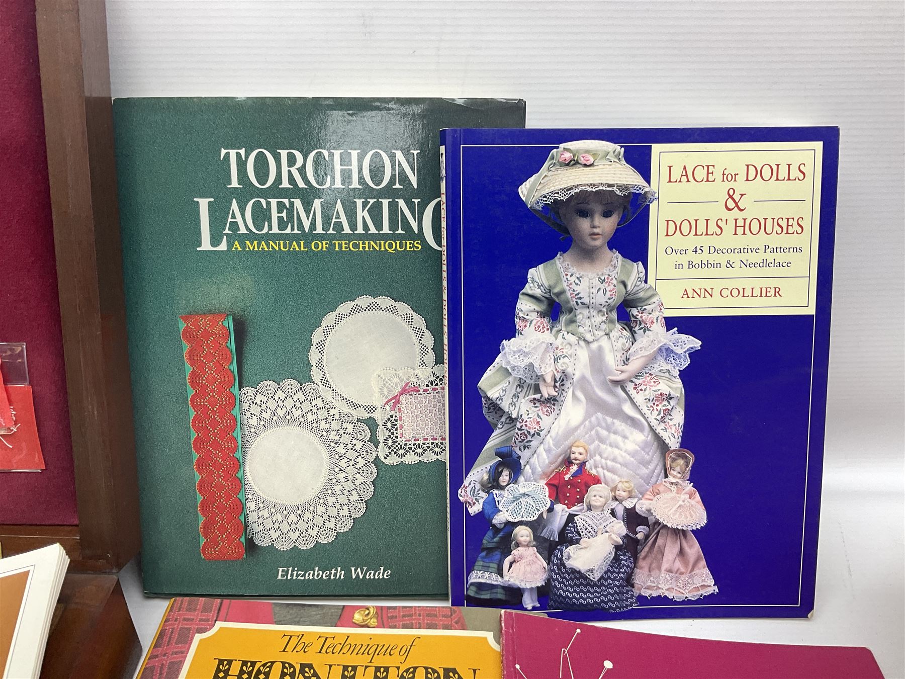 Collection of lace making wooden bobbins, together with lace making books and a handmade storage box