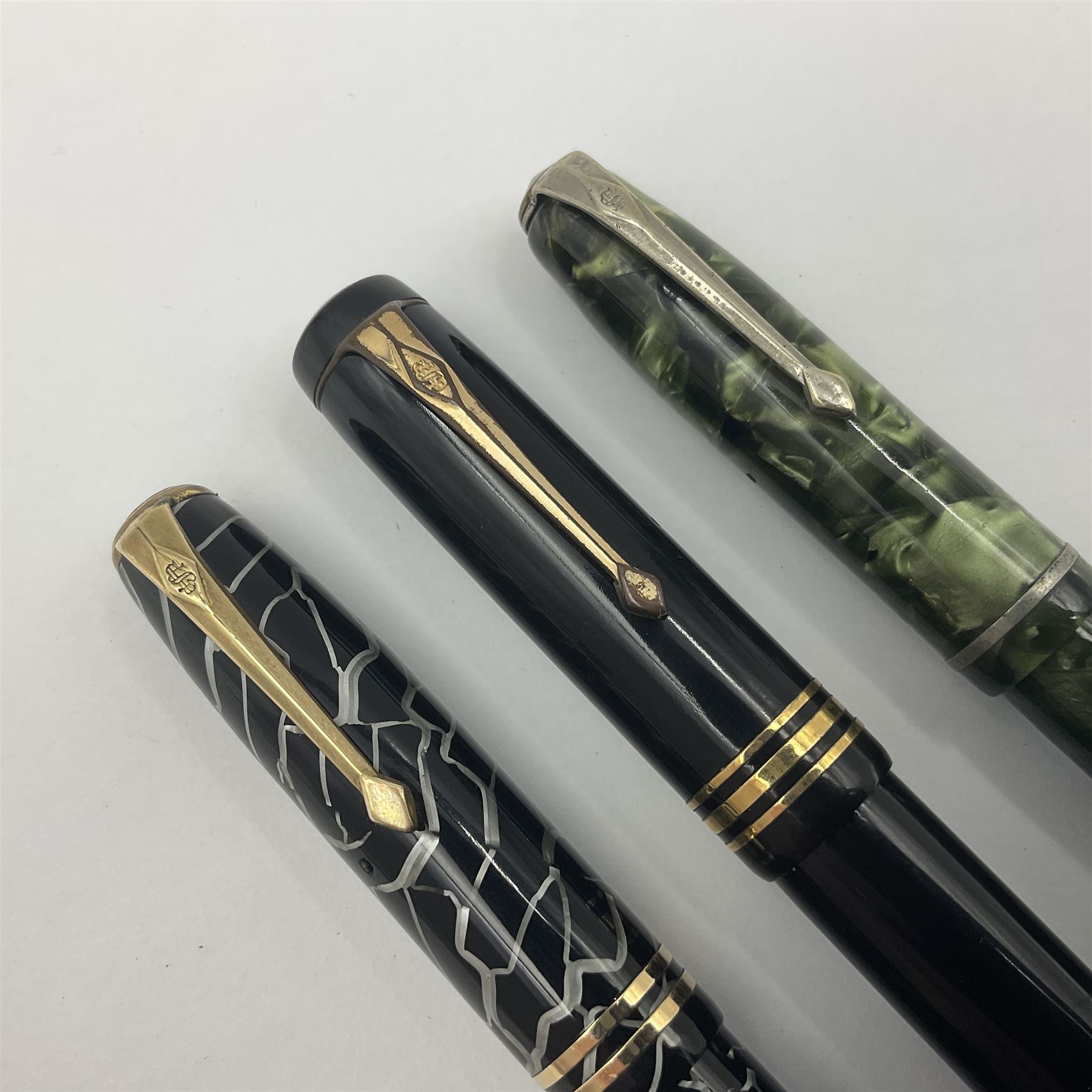 Three Conway Stewart fountain pens, comprising Cracked Ice 28 pen, the black and pearl white barrel engraved Conway Stewart 28 and double banded cap, with gold nib stamped 14ct, together with a Conway Stewart 75 lever fill pen, the green marble barrel and cap with single band and gold nib stamped 14ct and Conway Stewart 55 lever fill fountain pen with black barrel and cap with single broad band and two narrow bands with gold nib stamped Duro 14ct, largest L13cm