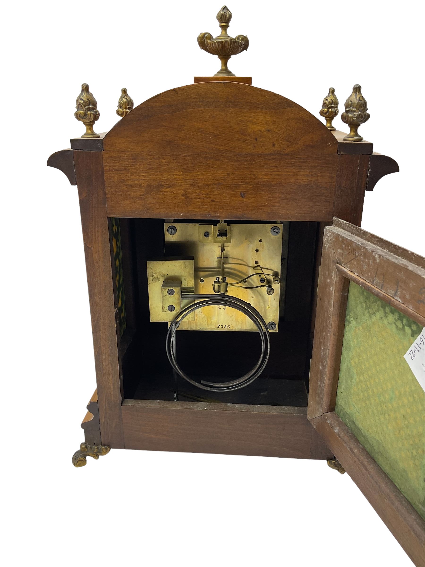 German - 19th century 8-day walnut bracket clock, striking the quarters on two coiled gongs, case with a break-arch top surmounted by cast brass finials, canted corners to the front with cast brass caryatids and sound frets to the sides, brass break arch dial with a silvered chapter ring, steel gothic hands, spandrels, and pendulum regulation dial. With pendulum.