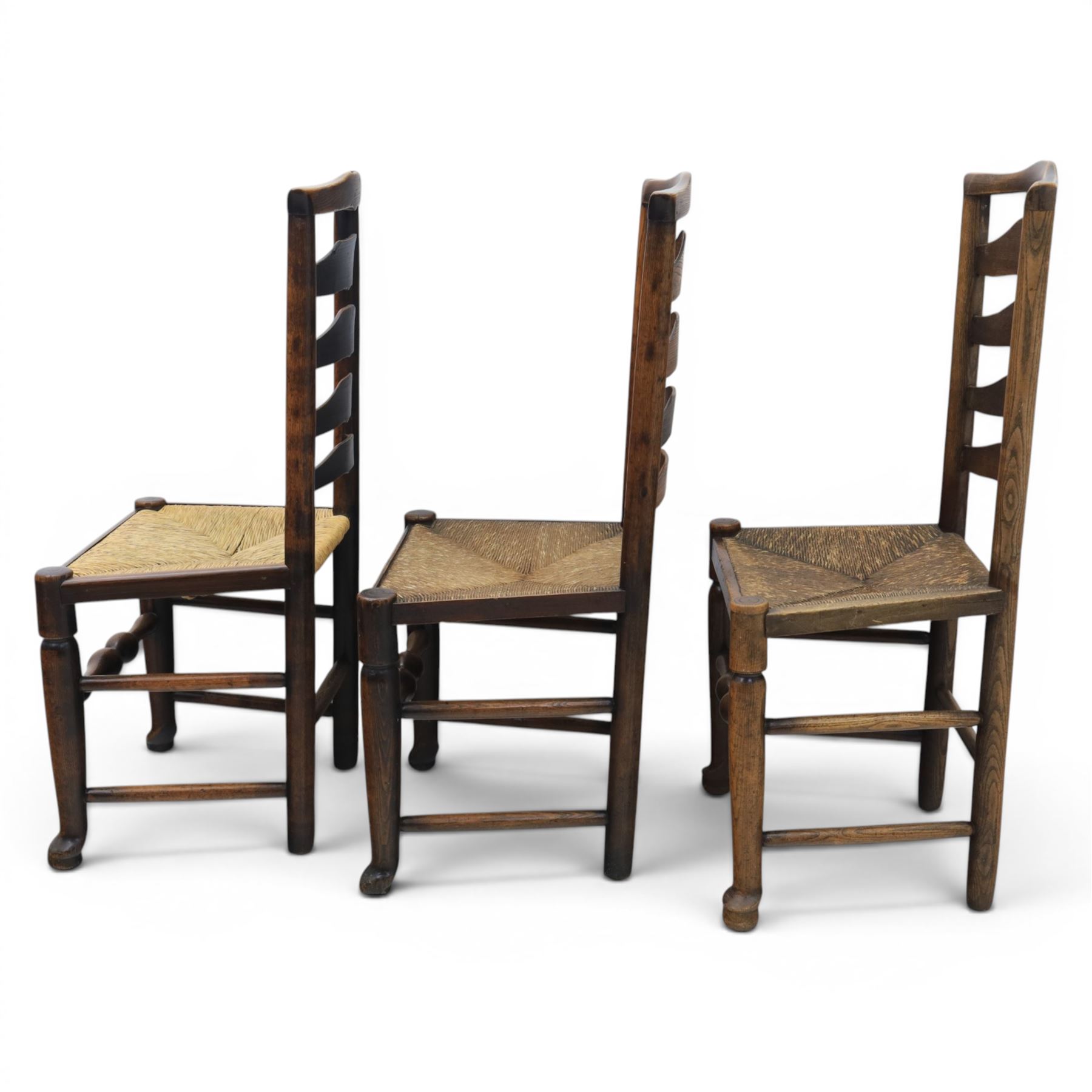 Set of seven (6+1) Georgian design country elm Lancashire dining chairs, ladder backs with rush seats, turned front leg stretcher on pad feet, height of seat 44cm, complete with fitted tie on cushions
