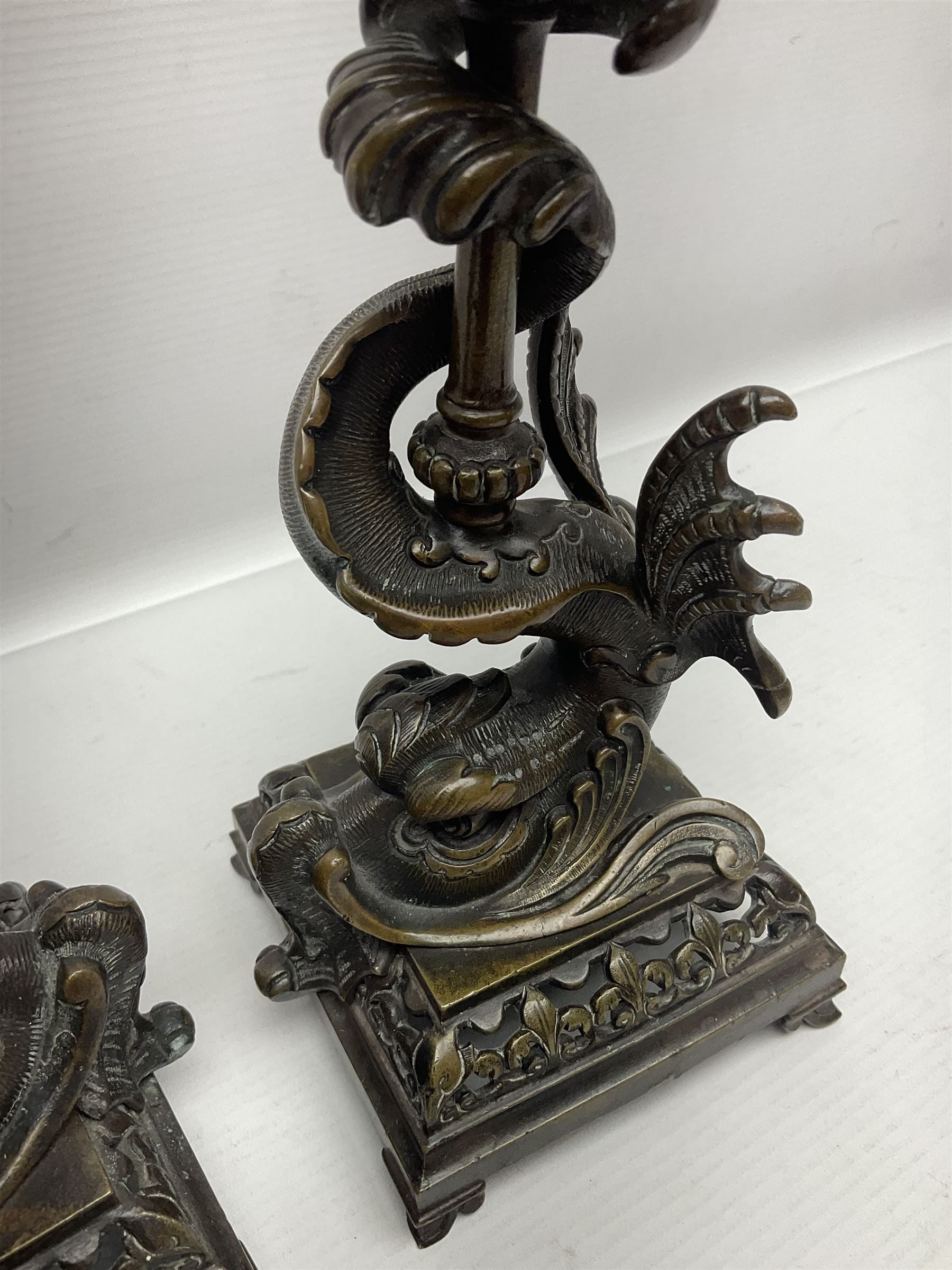 Pair of late 19th/ early 20th century brass candlesticks in the form of dolphins upon a stepped base with Fleur-de-lis design, H32cm 