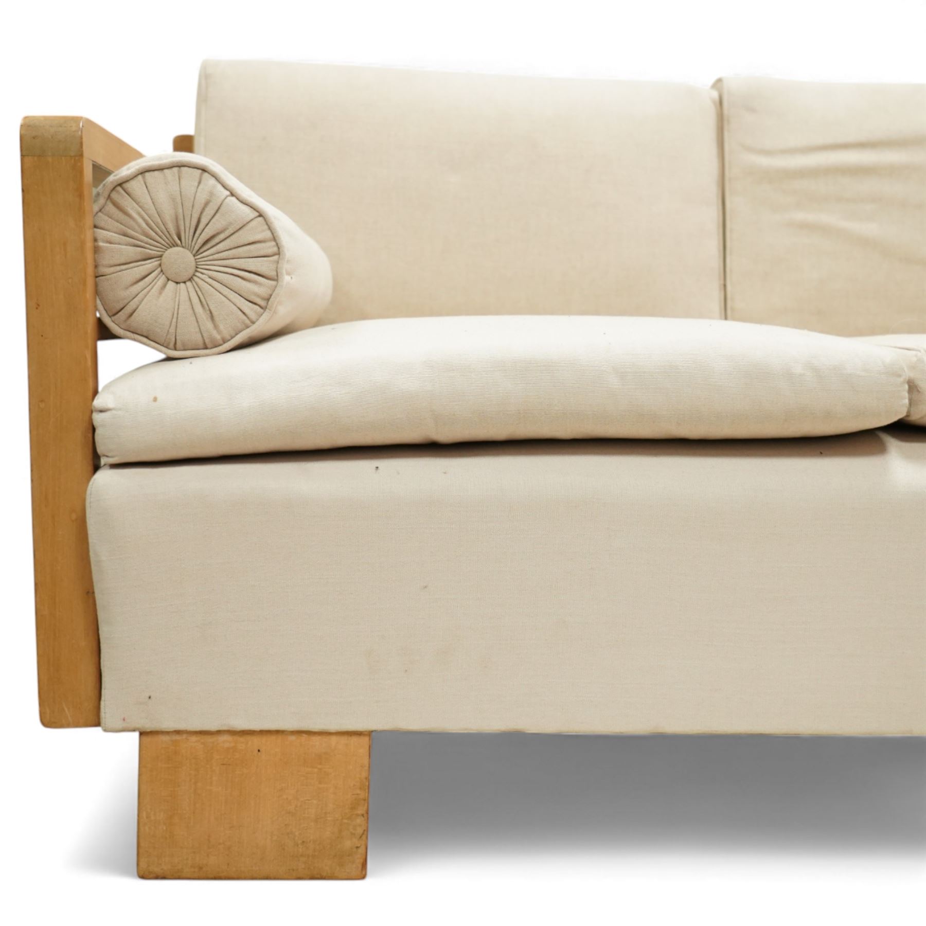 Mid 20th century German Art Deco oak framed divan day bed, rectangular form with slatted side supports, upholstered in cream linen with three removable back cushions, three seat cushions and cylindrical bolster arms, on block feet