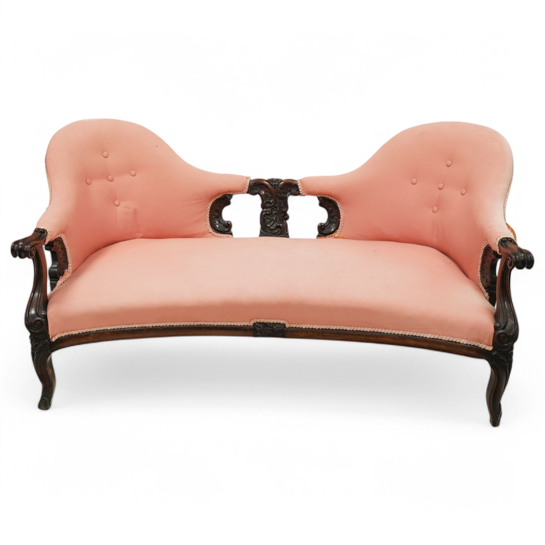 Mid-19th century carved rosewood double-ended settee, double spoon back with central splat carved with C-scrolls and shells, upholstered in pink buttoned fabric, scroll carved arm terminals on shaped supports, on leaf and flower head carved cabriole feet 