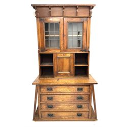 Arts & Crafts oak cabinet on chest, projecting cornice above to lead glazed cabinet doors, two shelves flanking single fall front enclosing fitted interior, four graduating drawers