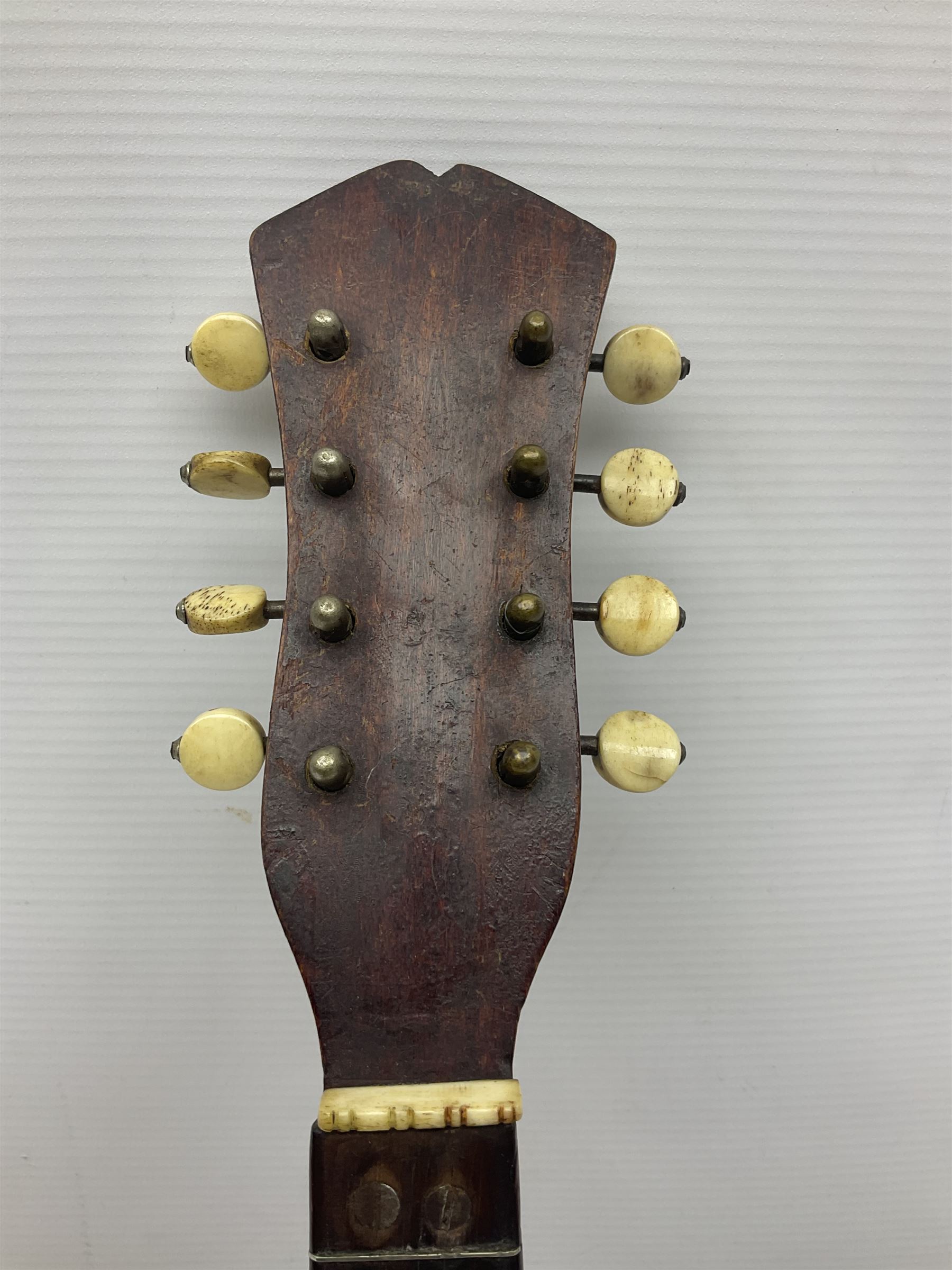 Late 19th century Italian lute back mandolin with segmented bowl back, bears label Gennaro Maglioni Napoli L61cm; in ebonised wooden case; together with another similar damaged Italian lute back mandolin for restoration or spares (2)