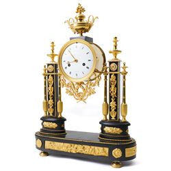 French-Early 19th century 8-day ormolu and polished black slate portico clock, case surmounted with a twin handled urn with flowers, supported by two square pedestals with finials and trailing floral mounts on oval bases, raised on an oval plinth with toupie feet, enamel dial signed 