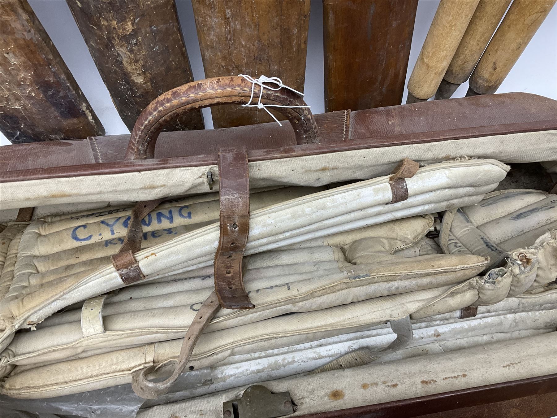 A Vintage leather cricket bag and equipment, to include cricket bats, balls, wickets, and pads. 