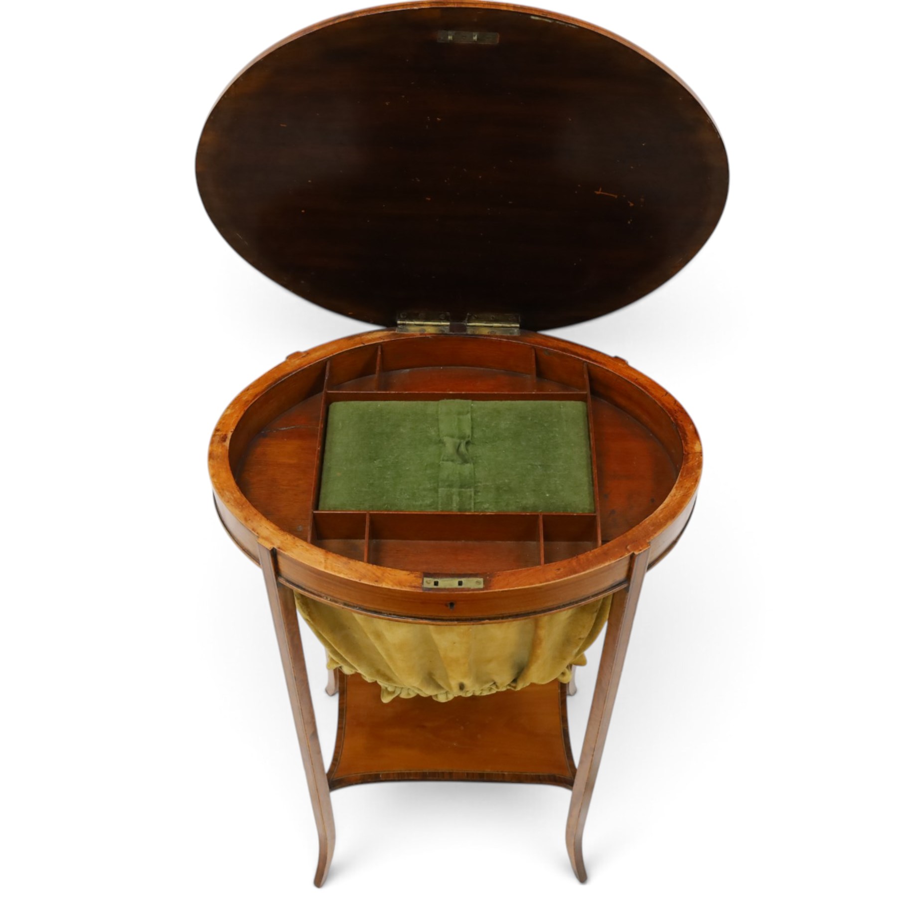 Edwardian inlaid satinwood oval sewing or work table, crossbanded and ebony-strung hinged top enclosing fitted compartment and olive-green upholstered well, raised on square tapering splayed supports united by under-tier 
