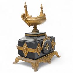 French- late 19th century 8-day mantle clock in an imposing Belgium slate case with gilt metal ornamentation. Stepped rectangular case with an angled top and square plinth surmounted by an oval shaped gilt urn with scroll handles, case with continuous strapwork and oval medallions displaying portraits from classical antiquity, raised on a gilt metal base with splayed feet, conforming unenclosed slate dial with gold incised Roman numerals and brass Fleur de Lis hands, Parisian twin train rack striking movement with pendulum regulation, striking the hours and half hours on a bell. With pendulum.