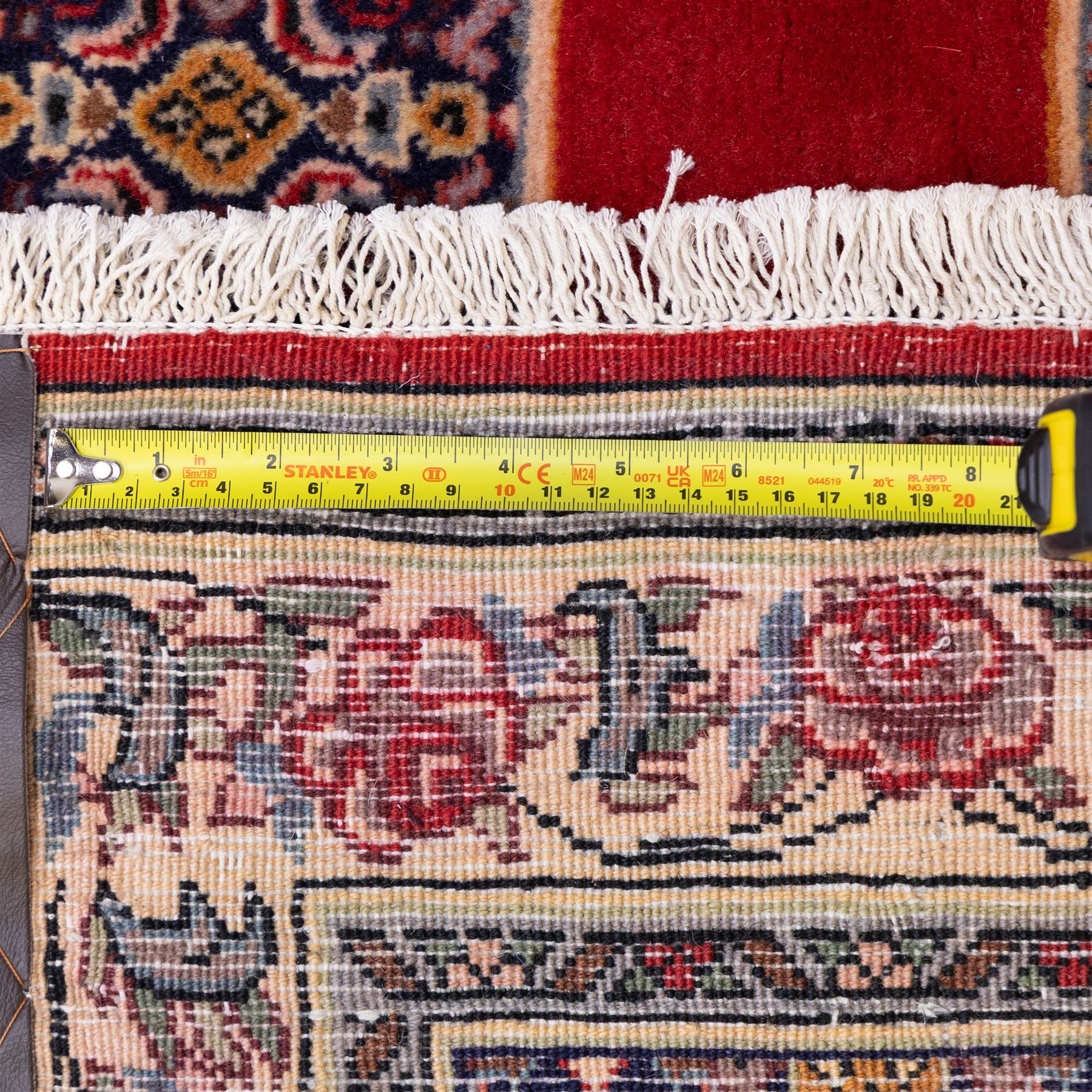 North West Persian Senneh hand-knotted runner, field with a central stepped medallion design in madder red and cream, in a series of linked lozenges filled with finely composed floral sprays and stylized roses, surrounded by densely patterned repeating geometric motifs, enclosed within a narrow main border with floral meander, flanked by multiple guard stripes, with fringe ends 