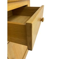 Contemporary light oak bookcase display cabinet, fitted with  two glazed doors enclosing two shelves, above two drawers and cupboards