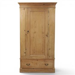 Traditional waxed pine single wardrobe, featuring single panelled door above base drawer, loop handles