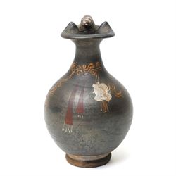 South Italian Gnathian terracotta oinochoe (jug) Apulian or Campanian (Late 4th century BC c.325-300 BC) of elegant ovoid form with trefoil mouth and single strap handle, the handle terminating in a stylised serpentine motif merging into the pouring lip, the vessel covered in a black gloss slip and decorated in added red, white and yellow with a theatrical mask, fillets and scrolling Dionysiac vine motifs, H19cm 
Notes: Gnathian ware takes its name from Egnathia in Apulia and is characterised by a black-gloss ground with added-colour decoration; the theatrical mask, fillets and vine scrolls relate to Dionysiac imagery associated with the symposium and theatre in South Italian Greek culture of the late fourth century BC. A very similar oinochoe is held in the The Metropolitan Museum of Art, object number 76.12.8