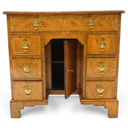 George III figured and burr walnut kneehole desk, the shaped rectangular top with feather and crossbanding surrounded by a moulded edge, fitted with single frieze drawer over three graduating drawers to each side, flanking a central recessed cupboard, lower moulded edge on bracket feet
Provenance: Kirkham Hall