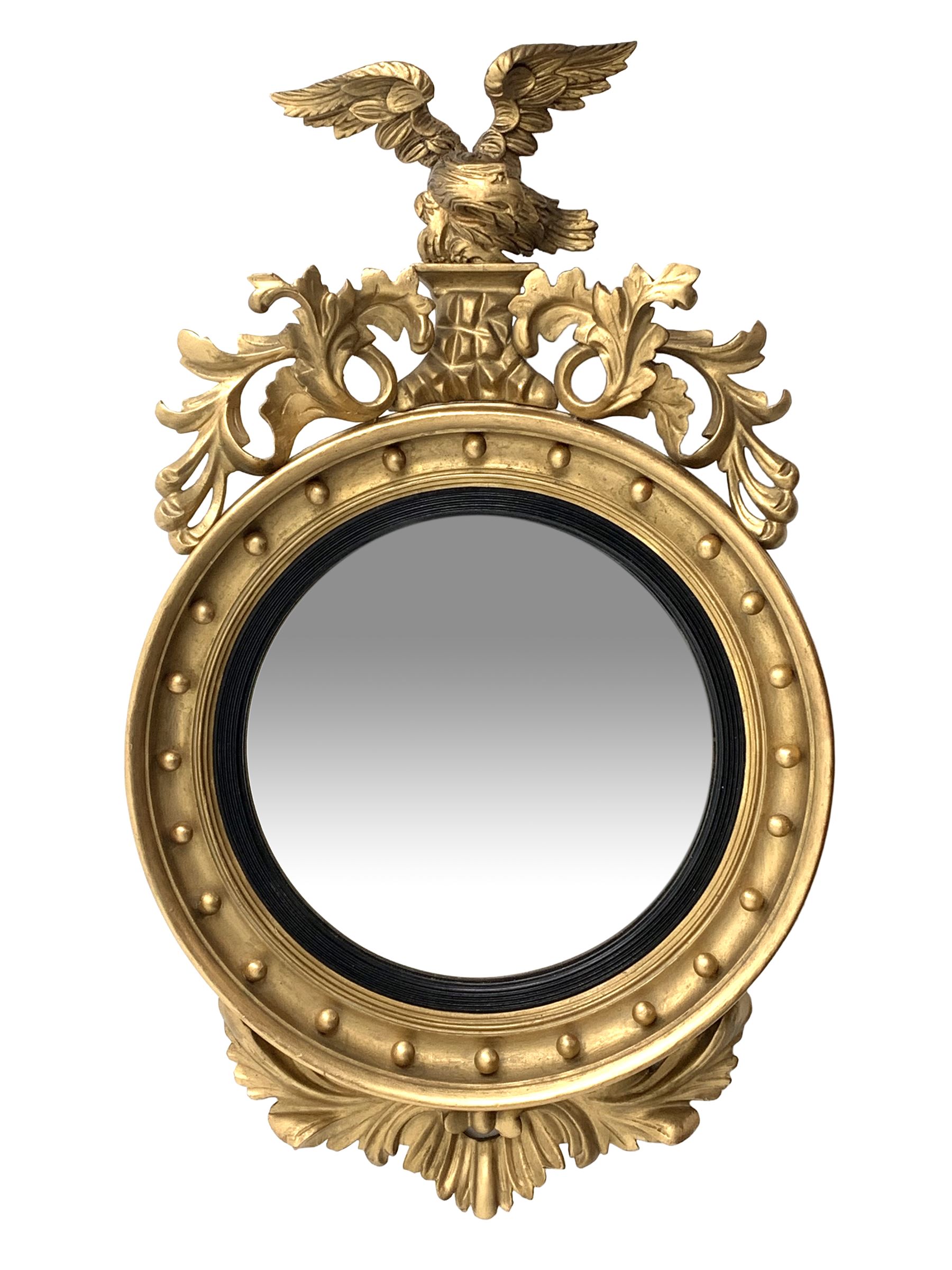 Large Regency carved wood and gesso circular convex mirror, eagle pediment on platform flanked by acanthus leaf scrolls, moulded surround and ebonised slip