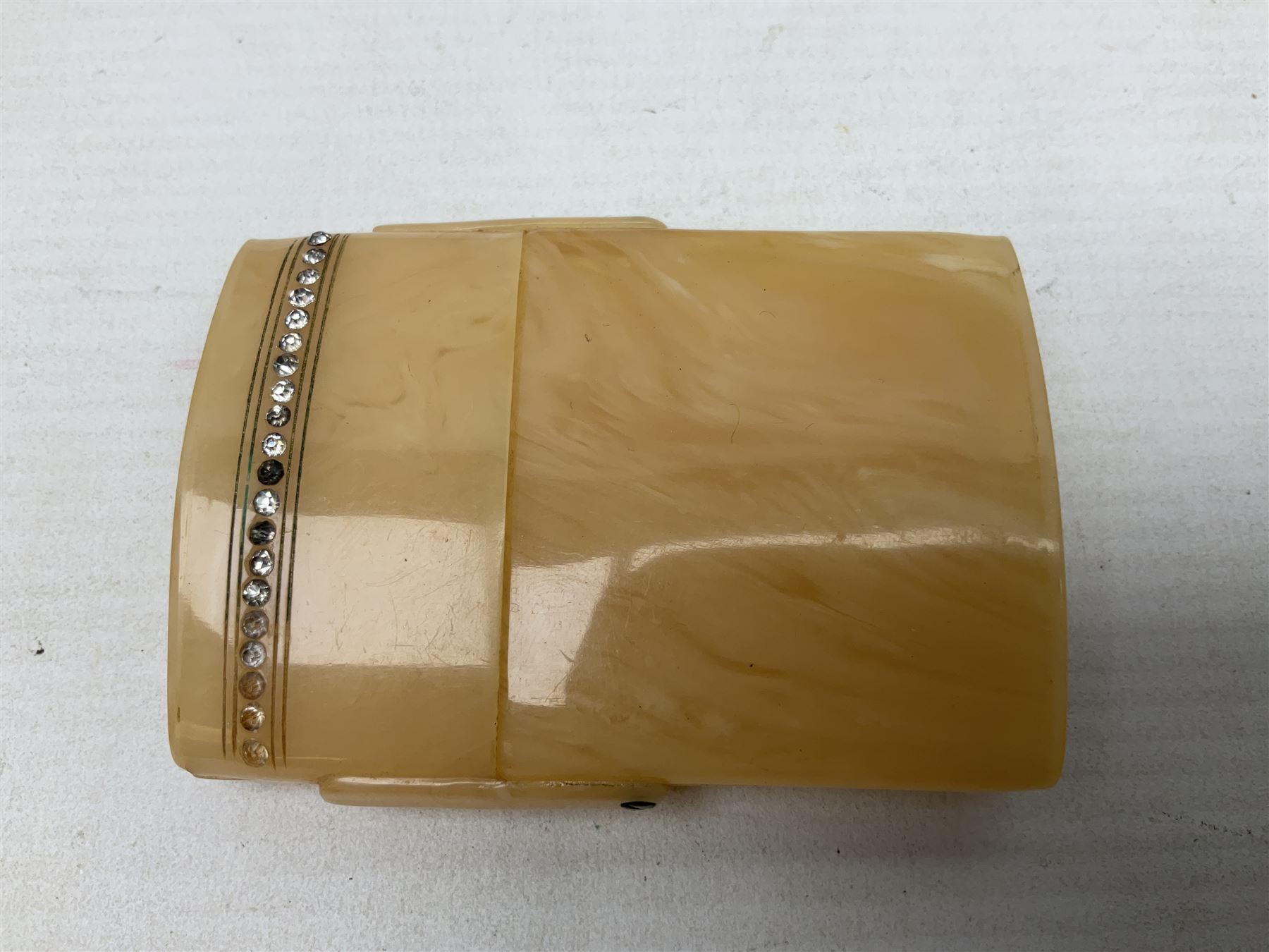 Mother of pearl and abalone inlaid card case, with central diamond shaped panel engraved with foliate decoration, together with a simulated mother of pearl card case of book form with green sun rays to cover, and simulated wood effect cigarette case with hinged lid with diamante style banding, largest L10cm