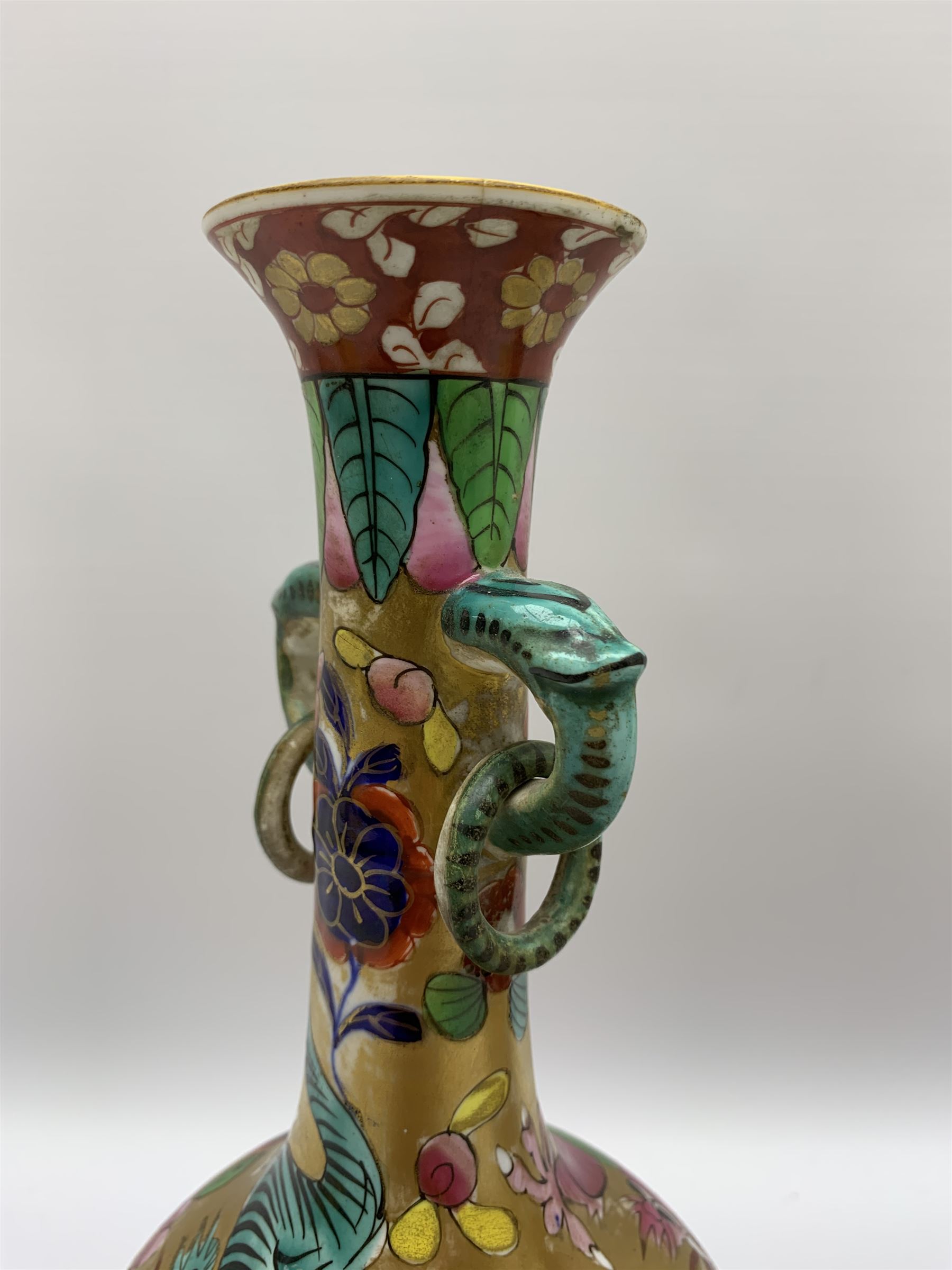 Pair of early 19th century Miles Mason vases, the baluster bodies with tall slender necks supporting twin stylised trunk handles with rings, decorated with Chinese dragons, butterflies, and blossoming flowers against a gilt ground, with spurious Chinese marks beneath in iron red, H27.5cm