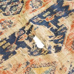 Antique Caucasian crimson ground carpet. the field decorated with three geometric indigo medallions with surrounding geometric motifs and guard lines