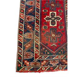 Persian red and blue ground rug, the field decorated with three stylised star medallions, surrounded by triple band border with repeating design