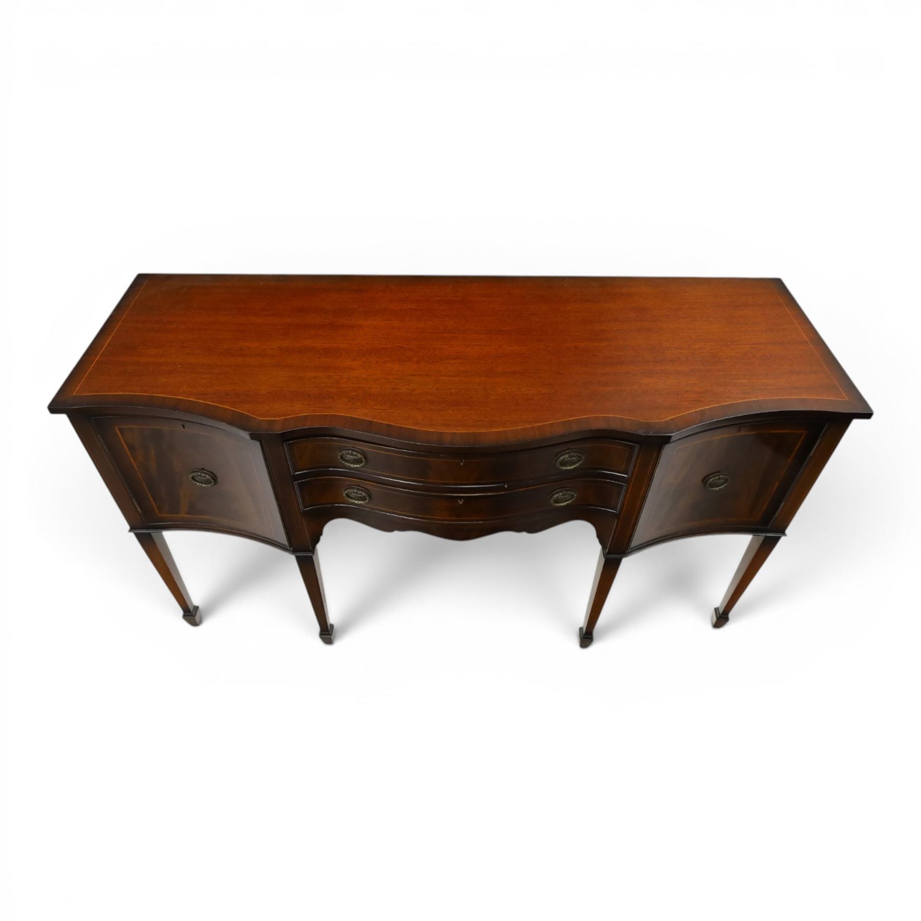 Georgian design mahogany serpentine sideboard, shaped top over two central drawers flanked by cupboard doors, flame mahogany veneered fronts with satinwood stringing, oval brass handles, shaped apron, on square tapering supports with spade feet