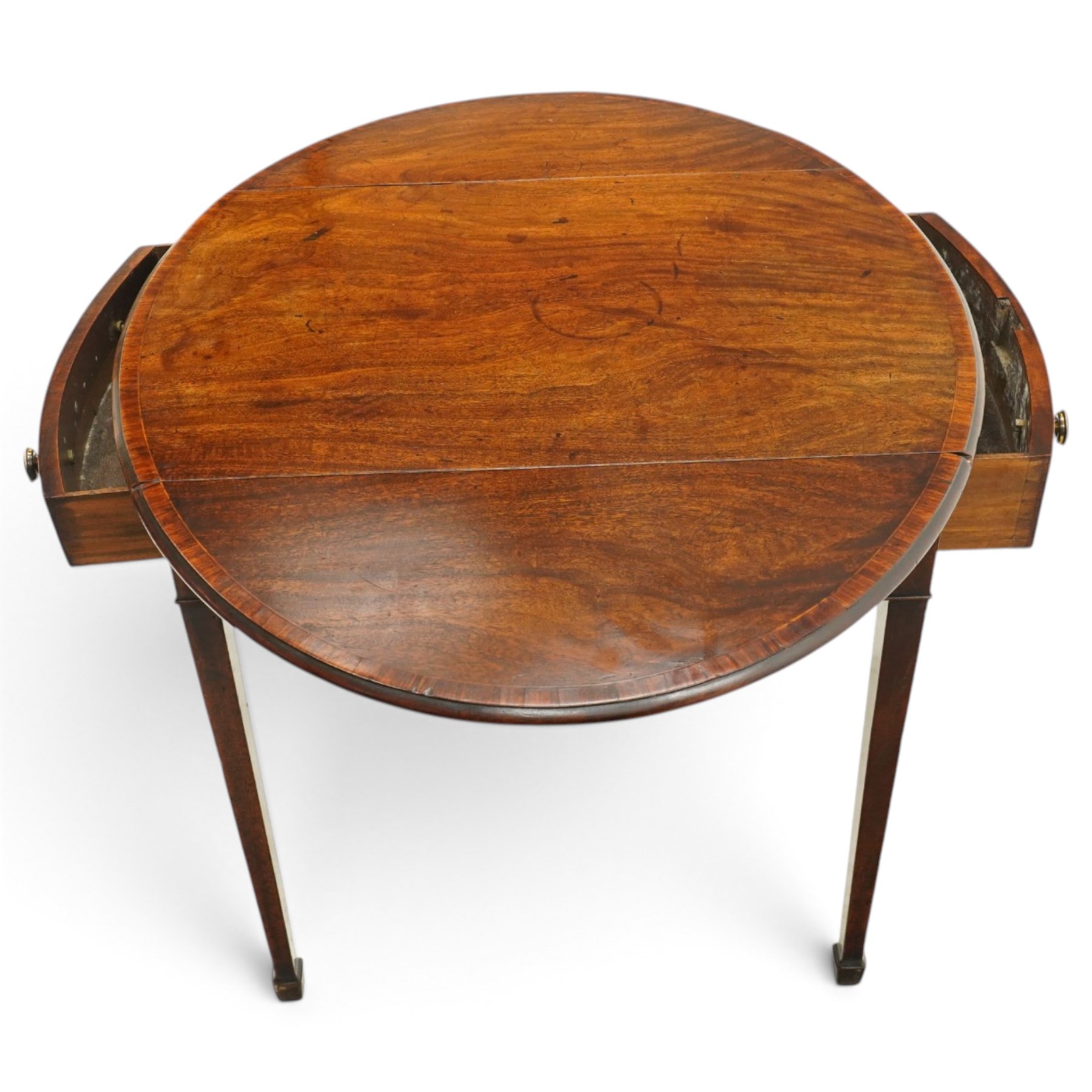 Small early 19th century George III mahogany Pembroke table of small proportions, the oval drop-leaf top with mahogany banding, fitted with twin opposing bow-fronted frieze drawers with brass pull handles, on square-tapering supports with spade feet