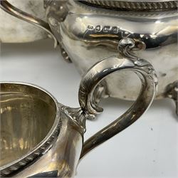 Five piece Edwardian silver tea service, comprising teapot and coffee pot, each with ebonised scroll handle, tea caddy with hinged cover, twin handled open sucrier, and milk jug, each of rounded bombe form, upon four paw feet, hallmarked William Adams Ltd, Birmingham 1904 and 1905, coffee pot H26cm
