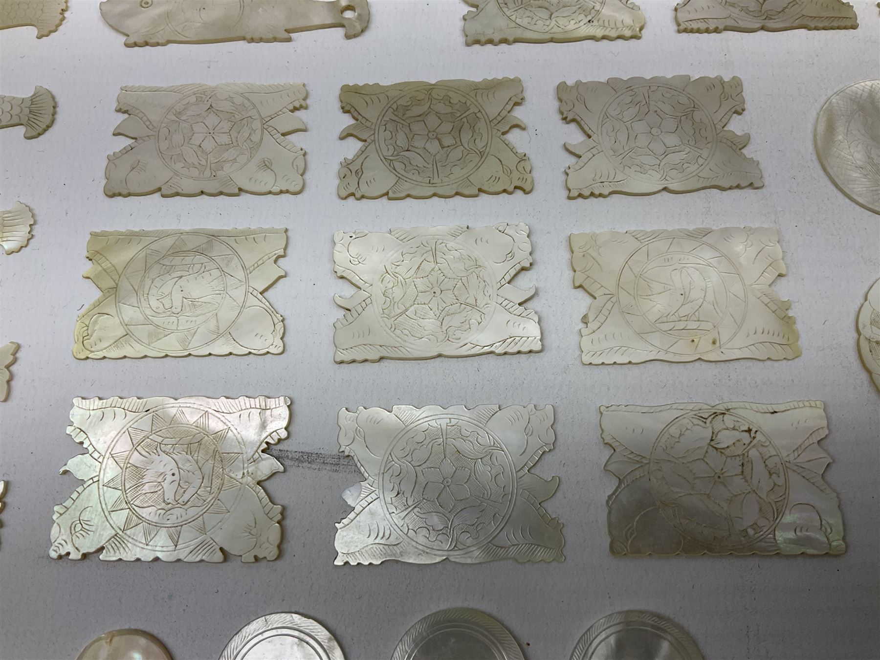 Collection of fifty two Chinese mother of pearl gaming counters or tokens, of various size and form including rectangular, circular and fish shaped examples, various decoration including floral motifs, largest rectangular examples L4cm