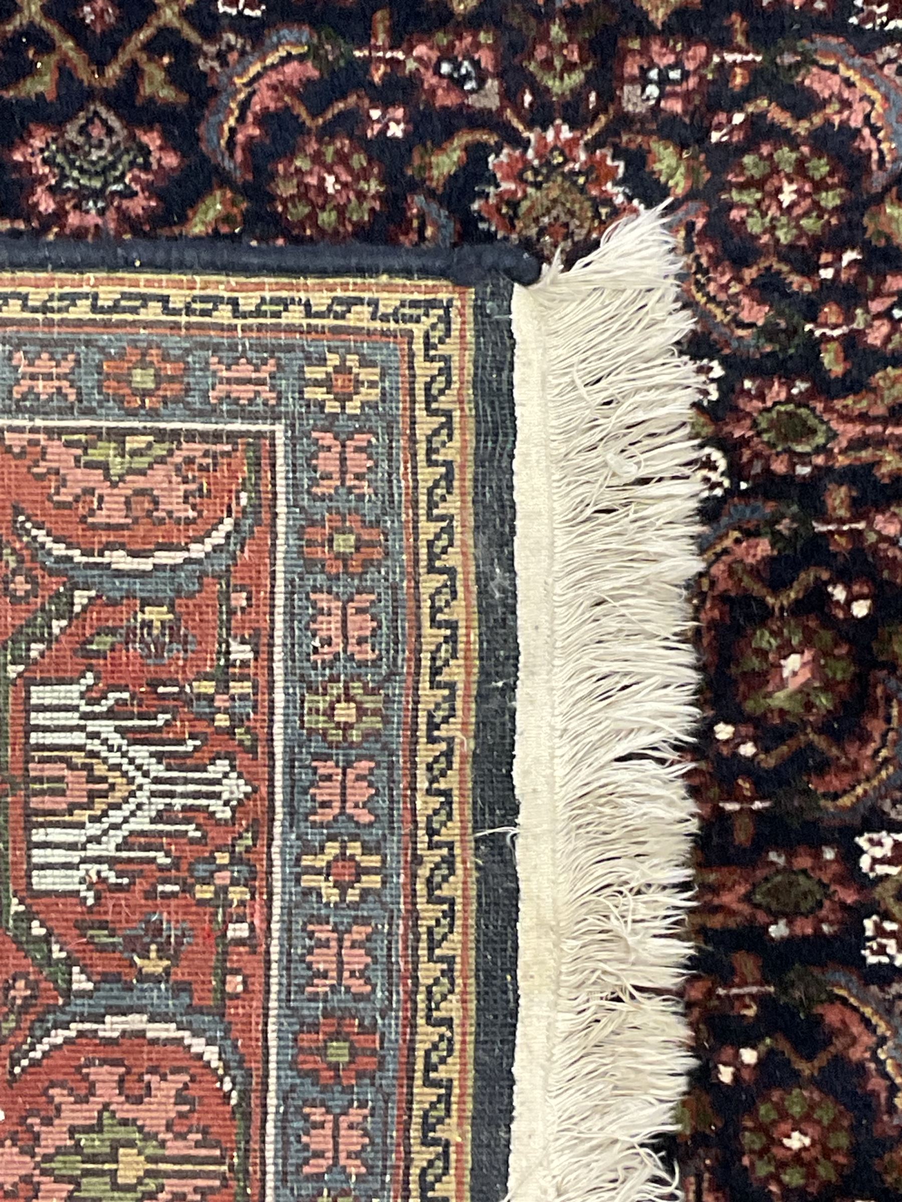 Persian Herati indigo ground rug, the field decorated with repeating Herati motifs, floral design border within guard stripes 