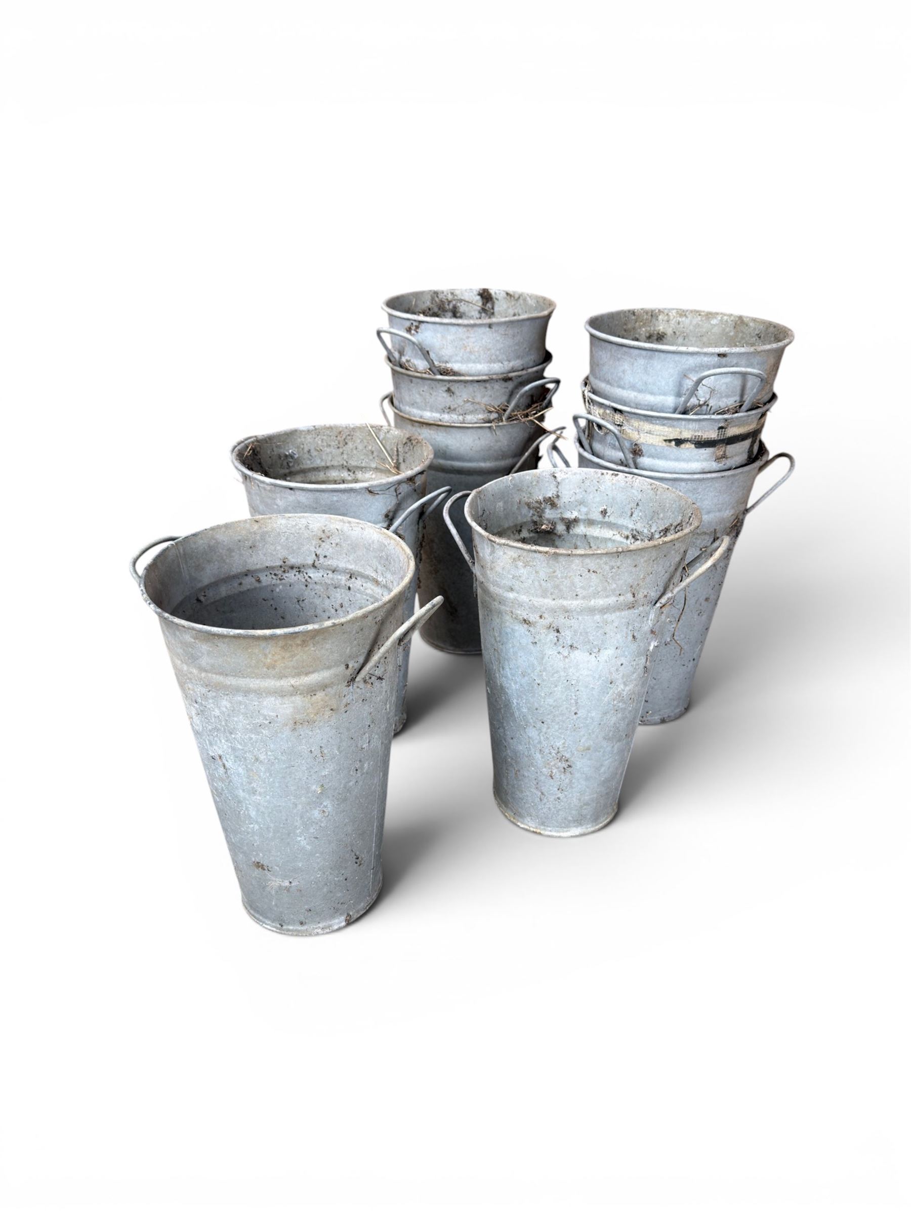 Nine galvanised flower buckets, tapering form with twin handles