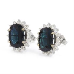 Pair of 18ct white gold sapphire and diamond cluster earrings, each stud set with a single oval cut sapphire, surrounded by sixteen round brilliant cut diamonds, total sapphire weight approx 6.65 carat, total diamond weight approx 1.00 carat