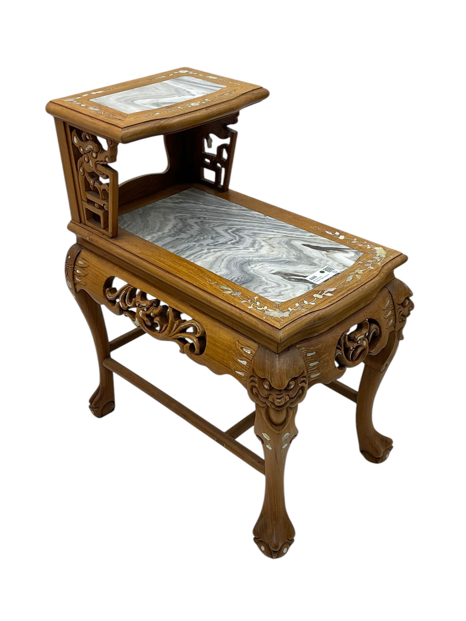 Pair of Chinese hardwood side or end tables, two moulded tiers with grey marble insets, inlaid with trailing foliate motifs in mother of pearl, with scrolling fretwork frieze rails, on cabriole supports with ball and claw feet united by plain stretchers 