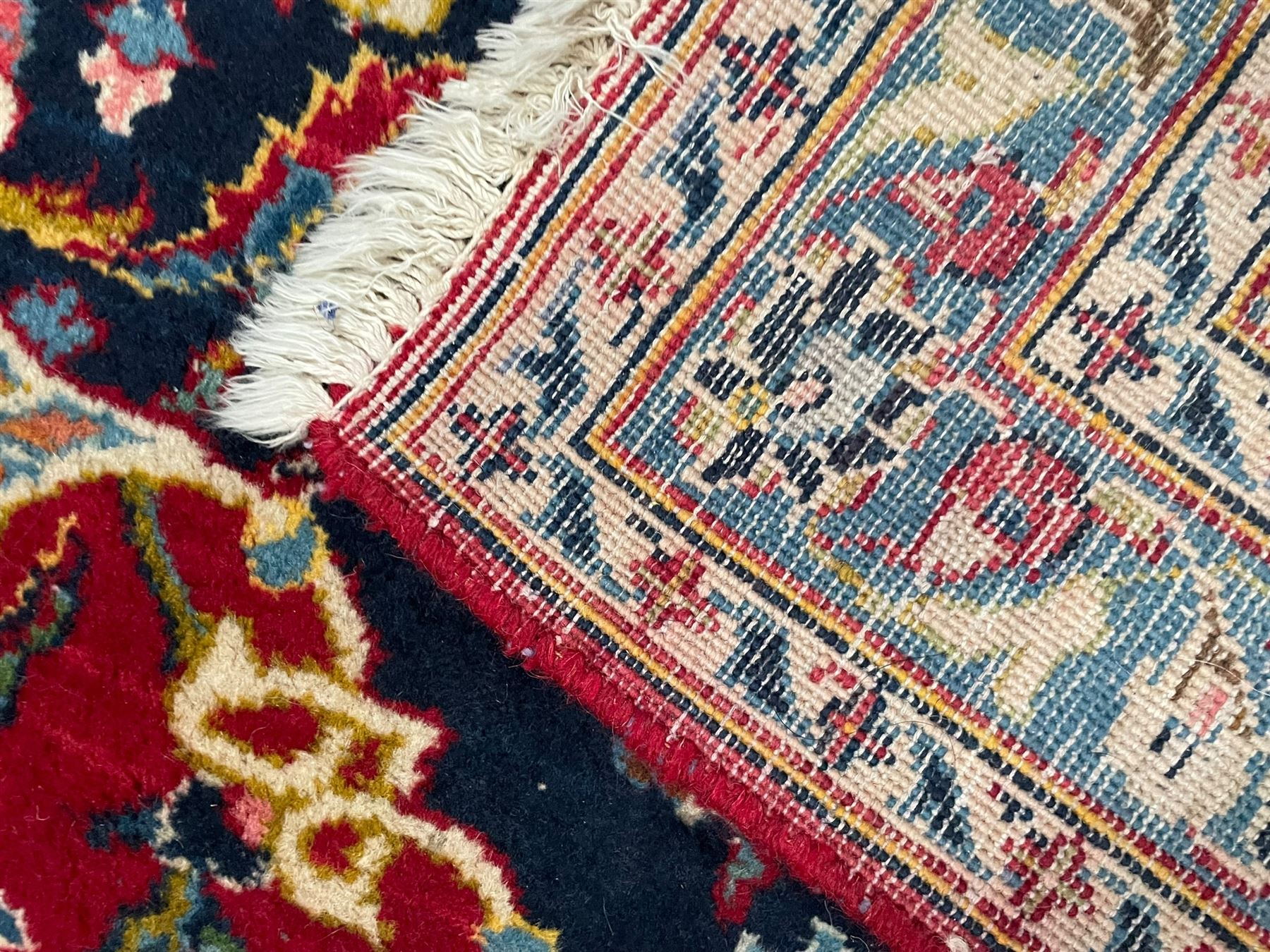 Persian Kashan crimson ground carpet, the central pole medallion decorated with flower heads, surrounded by trailing leafy branches and palmettes, scrolling border decorated with further palmettes, within floral pattern guard stripes 