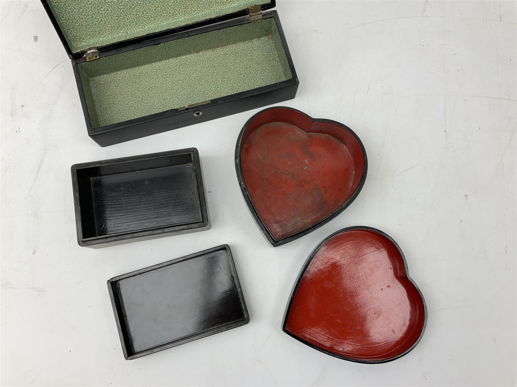  Late 19th / early 20th century Japanese lacquered table top cabinet, heavily decorated with mother of pearl inlay depicting blossoming branches, flowers and birds, the two hinged doors between longer drawers opening to reveal interior fitted with four short drawers, with lift up hinged canted lid, H28cm D9.5cm W23cm, together with mother of pearl inlaid miniature folding screen, dish decorated with walking figures with crimped edge, boxes decorated with flowers, birds and gilt etc