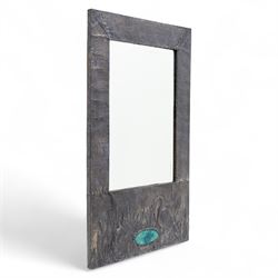 Early 20th-century Arts and Crafts pewter wall mirror, rectangular bevelled mirror plate within a punched pewter frame repoussé decorated with herons among reeds, with a central inset green enamel cabochon panel