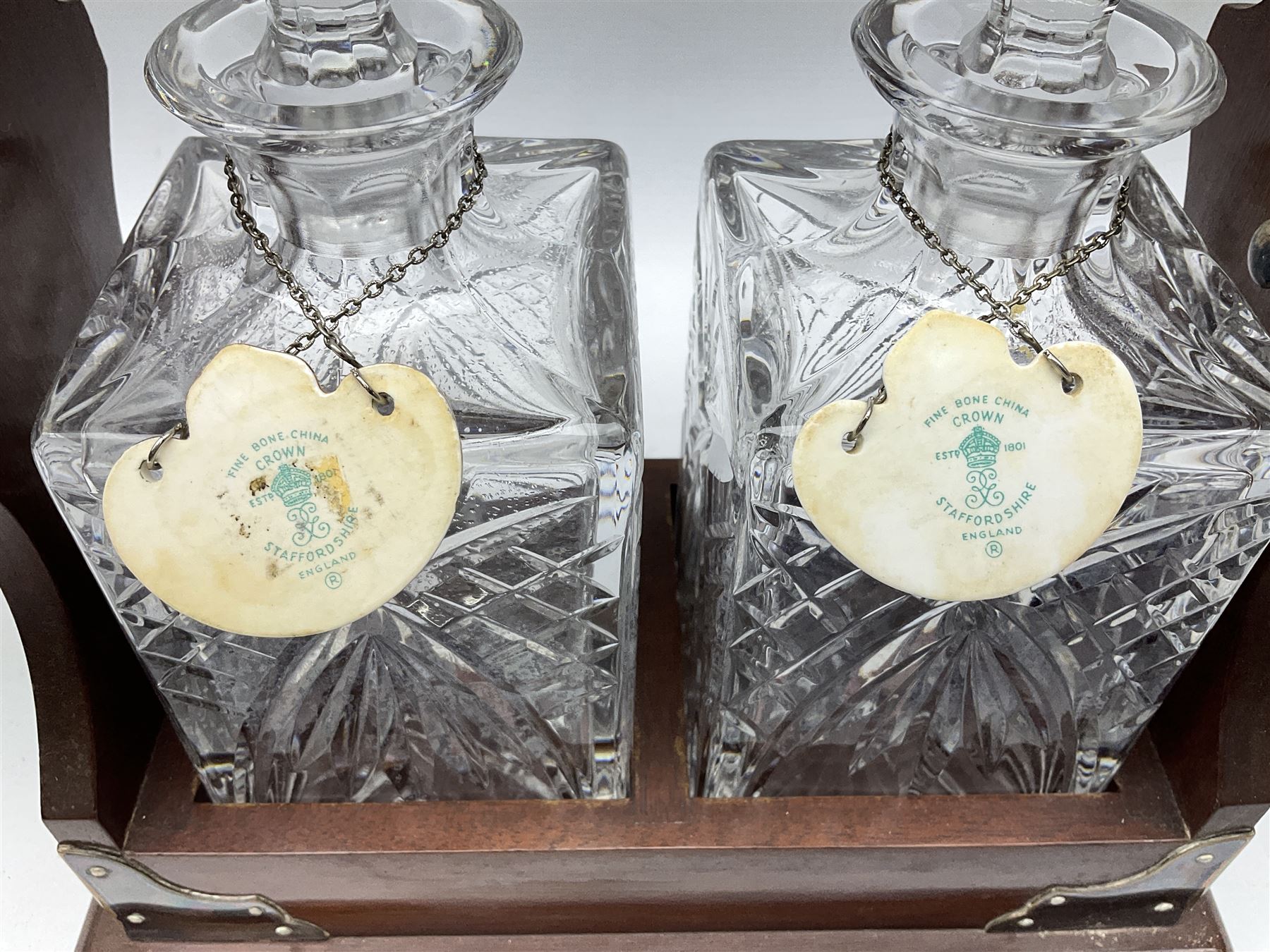 Late 20th century mahogany and silver plated two cut glass decanter tantalus, marked PB&S, with Whisky and Gin Crown Staffordshire ceramic decanter labels, H32cm