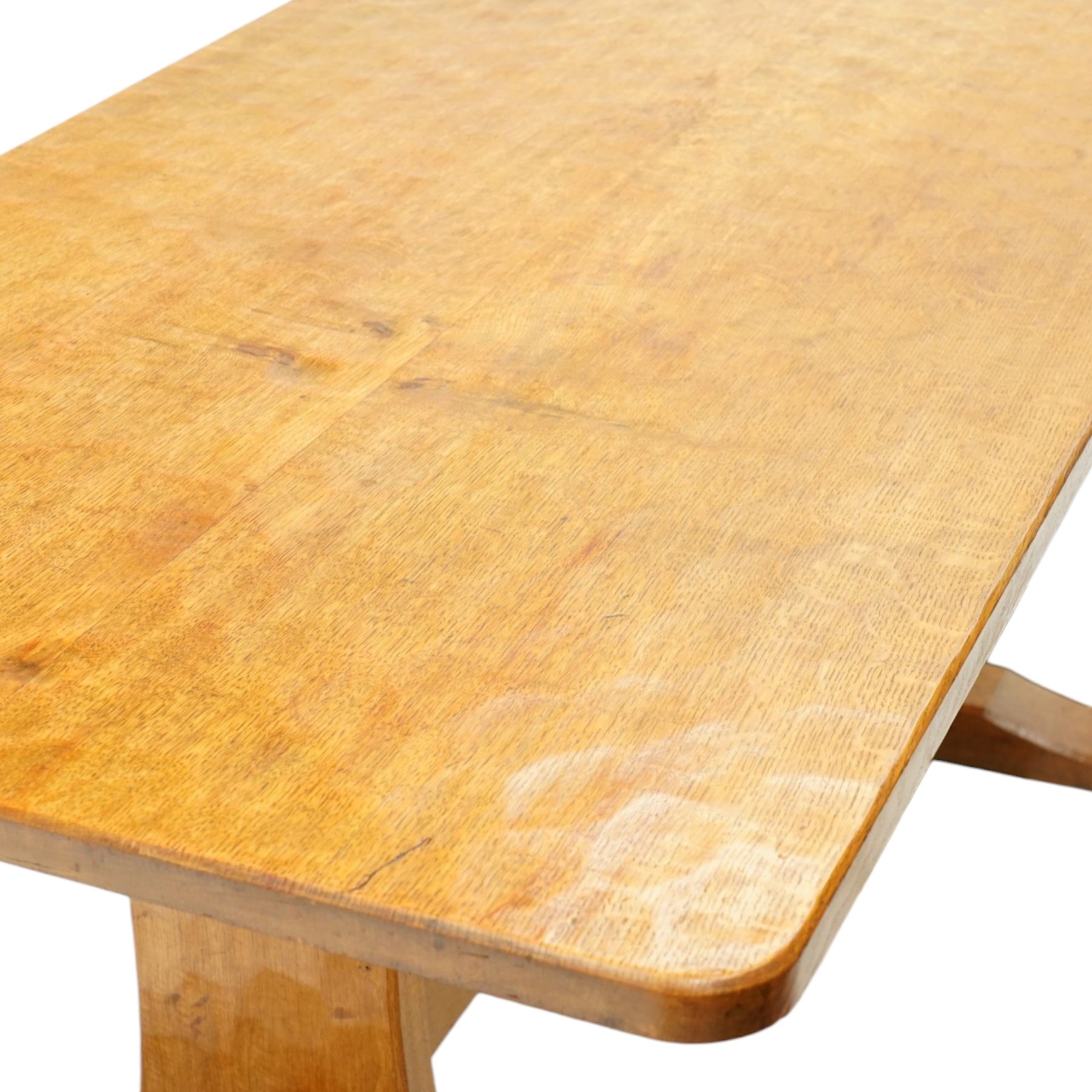 Acornman - adzed oak refectory dining table, rectangular adzed top with rounded corners raised on twin shaped end supports terminating to sledge feet united by pegged stretcher, carved with acorn signature