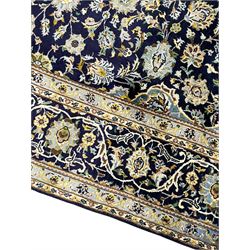 Persian Kashan indigo ground rug, central floral pattern pole medallion, the field decorated with palmettes united by trailing branches, repeating floral pattern border within guard stripes