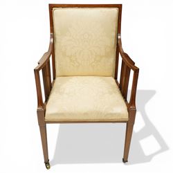 Arts & Crafts period inlaid mahogany framed armchair, swept arms with satinwood-strung supports over back and sprung seat upholstered in cream foliate damask fabric, on square tapering supports with castors