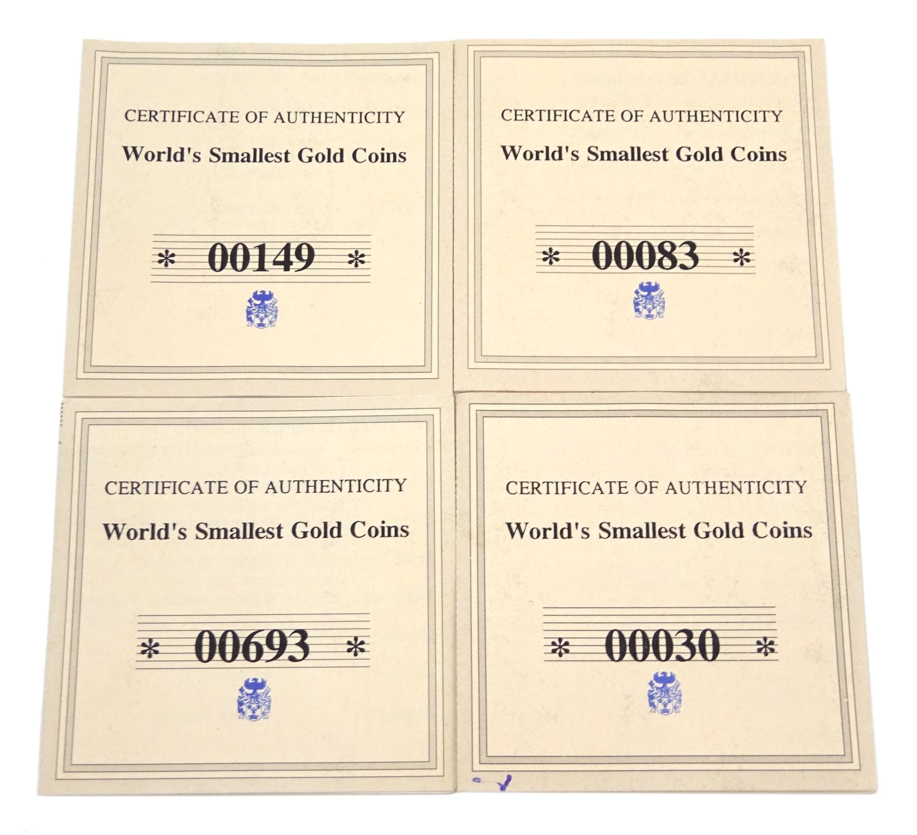 Four gold 'World's Smallest Coins', including three 24ct gold coins and one 14ct gold coin, all with certificates