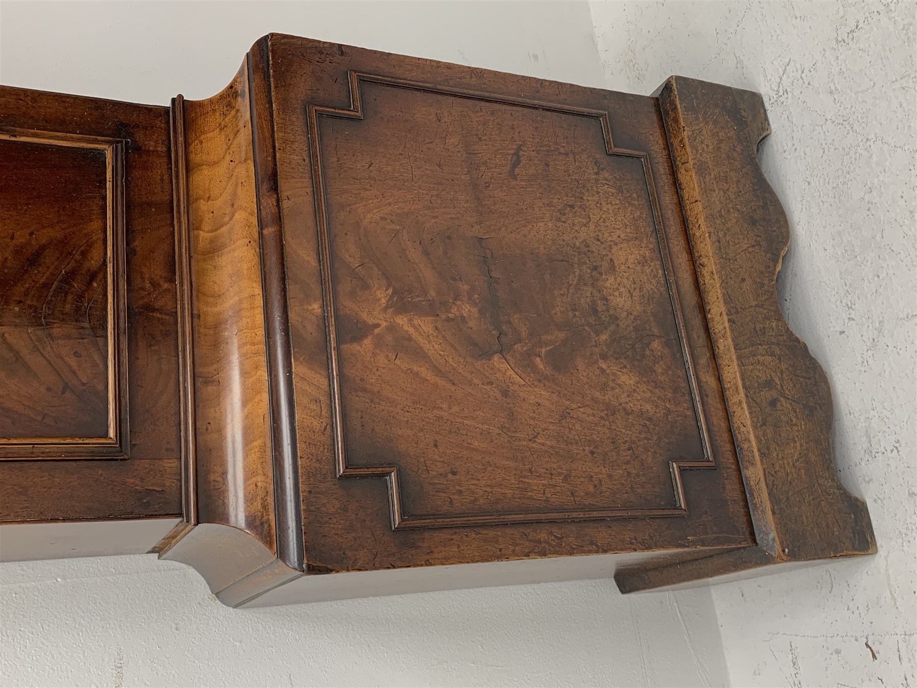 George III mahogany longcase clock, the hood with stepped moulded arch pediment above glazed door, fret work grille to each side, figured trunk door and base, enamel Arabic dial painted with country house scene and floral spandrels signed 'S. Wright, Watford', subsidiary seconds dial and date aperture, eight day movement striking the hours on bell, H212cm (two weights and pendulum)