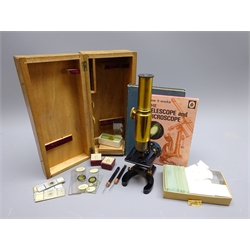 20th century lacquered brass monocular microscope on black painted metal base with rack and pinion focus H42cm in fitted wooden box with specimen glass slides and micro circles, together with two associated books and spare slides  