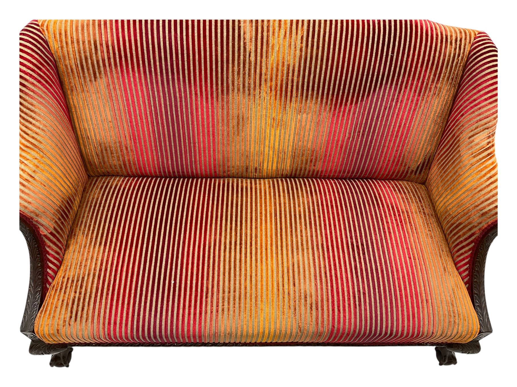 Mid-19th century mahogany two-seat sofa, upholstered in striped velvet fabric, the shaped backrest leading to outward-curved arms, carved apron with scrolling foliate details, raised on cabriole supports terminating in claw and ball feet