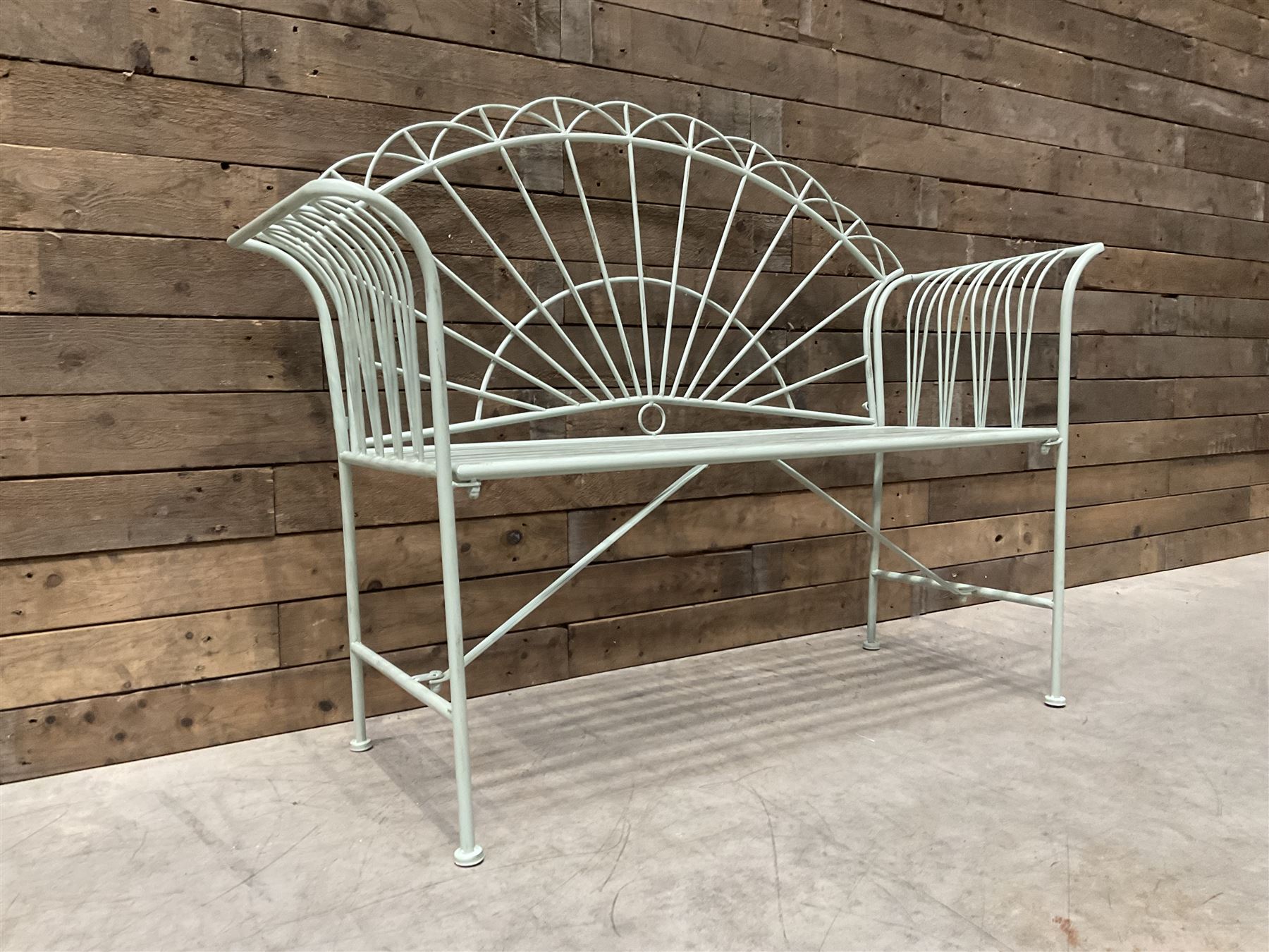 Wrought metal two seat garden bench, sunburst back, painted in pale green finish
