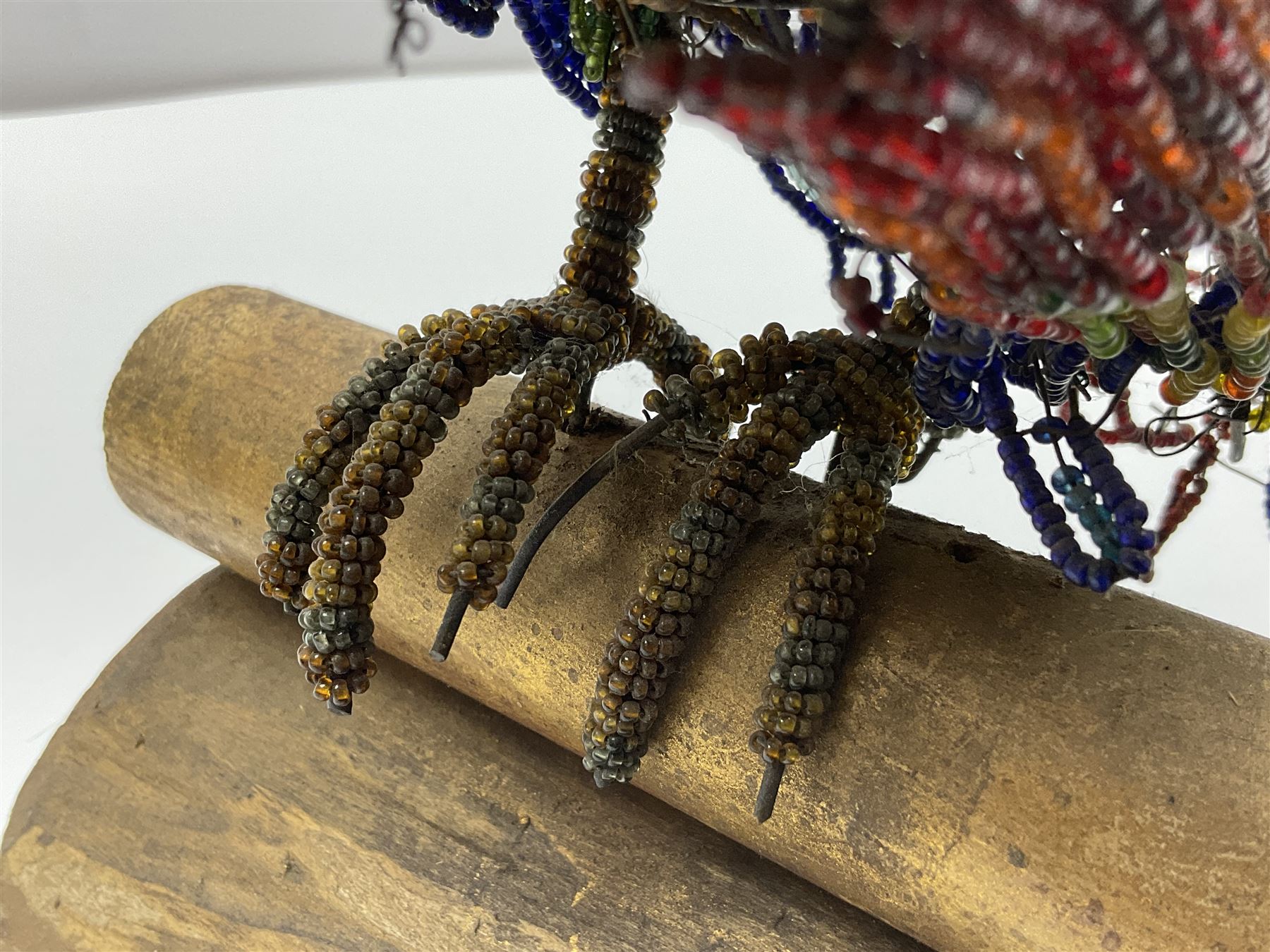 Victorian bead and wire model of a parrot, of polychrome beads, with glass eyes, on a wooden base, H24cm
