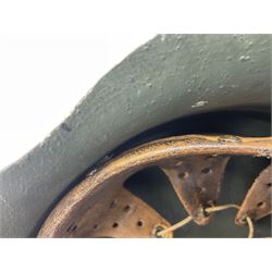 Fully restored German steel helmet, the camouflage painted exterior with two decals and replacement leather liner