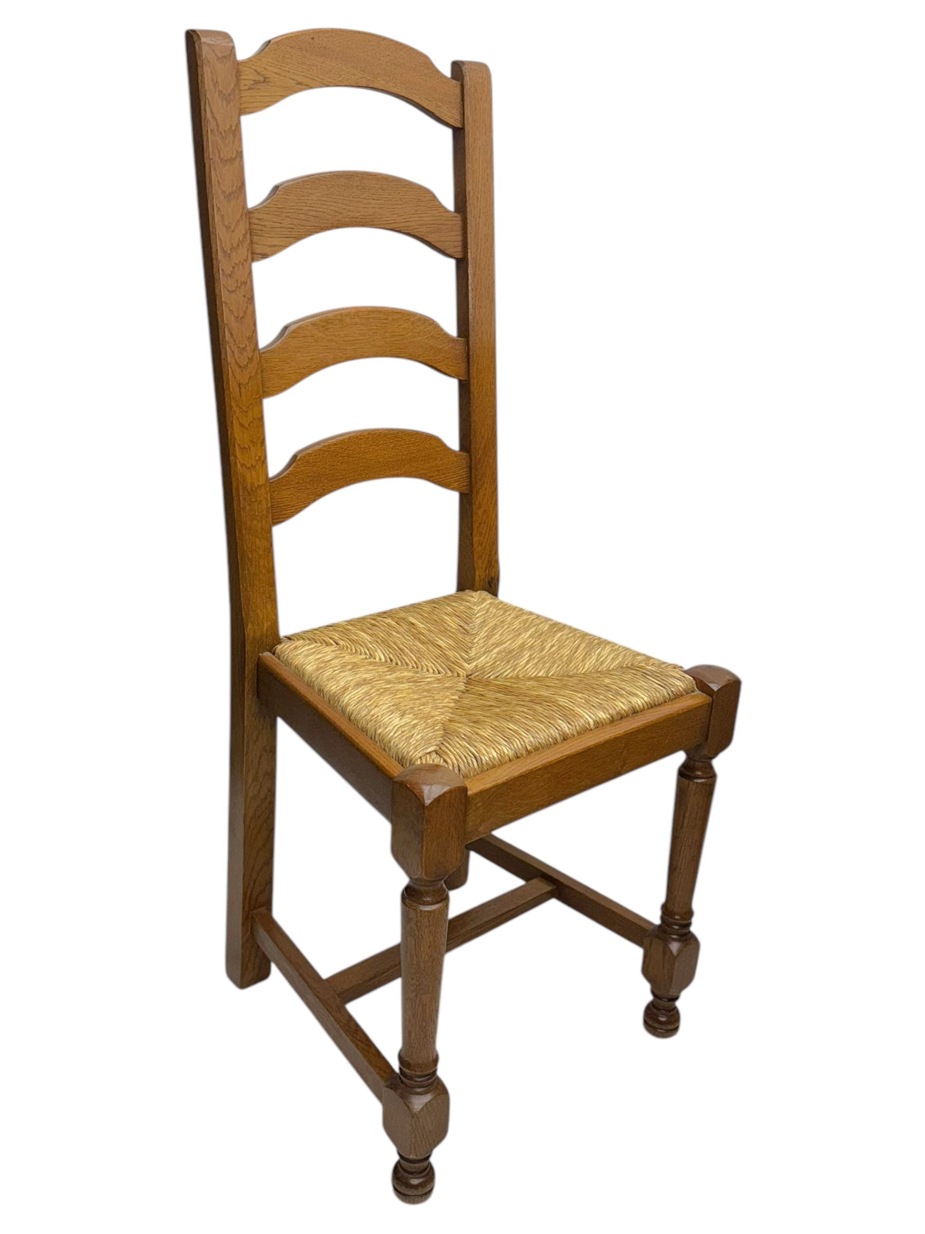 Oak extending dining table with elegant scrolled shaped double pedestal base and scrolled feet; together with a set of eight ladder back chairs with rush seats ((9) table closed 228x95x79cm chairs 106x38x44cm 